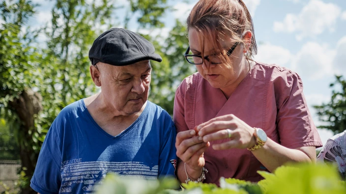 Mitarbeiterin bei der professionellen und fürsorglichen Alltagsbegleitung eines älteren Herrn